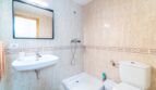 Helles Badezimmer mit Dusche, WC und Waschbecken, beige Fliesenwände mit Zierborte in Wohnung in Artà.
