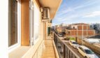 Sunny balcony of the apartment in Artà with metal railing, air conditioning and view of the quiet city street.