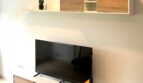 Modernes TV-Möbel mit Holzoptik und Wandregal im Wohnzimmer der sanierten Wohnung in Palma