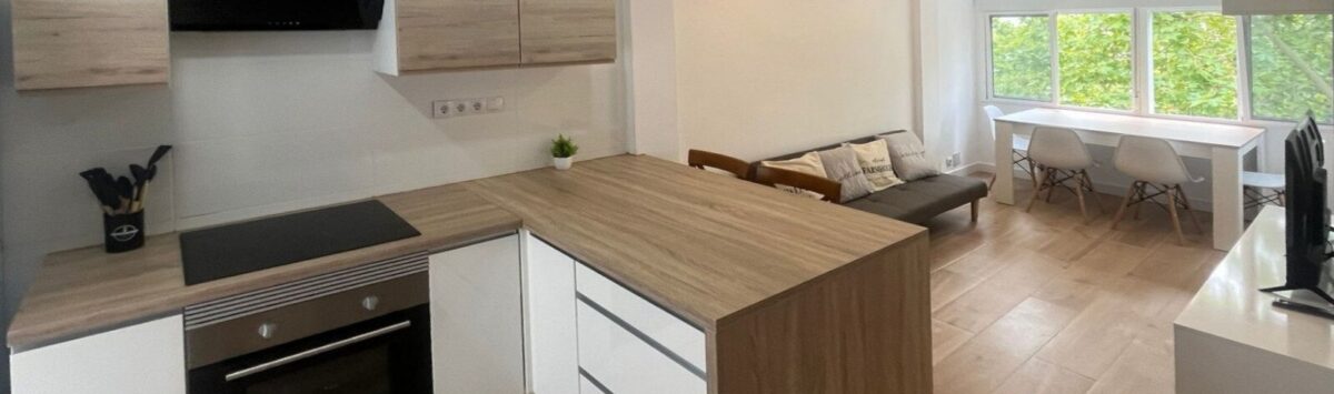 Offene Küche mit Kochinsel und Wohnbereich der kernsanierten 2-Zimmer-Wohnung in Palma