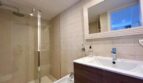 Modernes Badezimmer mit Regendusche, weißen Kacheln und Waschtisch in Strandnähe, El Arenal