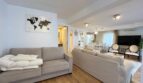 Helles Wohnzimmer mit beigen Sofas, Holzboden und Weltkartenkunst in Strandnähe, El Arenal