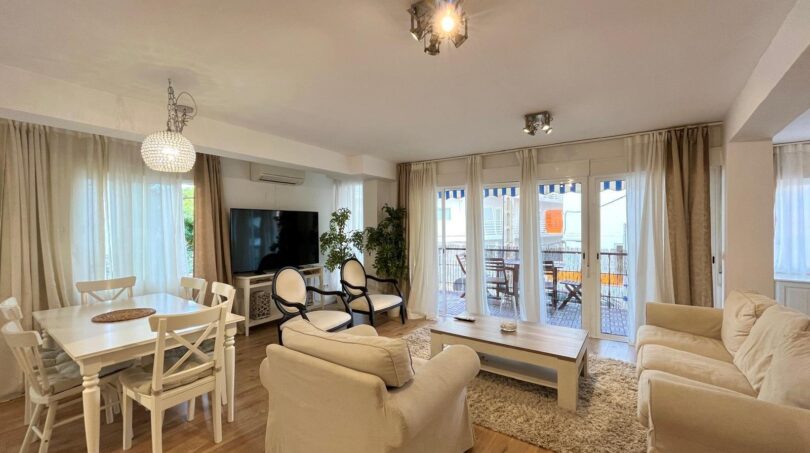 Helles Wohnzimmer mit cremefarbenen Sofas, weißem Esstisch und Balkonzugang in Strandnähe, Palma de Mallorca