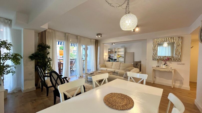 Helles Wohnzimmer mit Esstisch, Kronleuchter, Sofa und Balkonzugang in modernisierter Wohnung in El Arenal