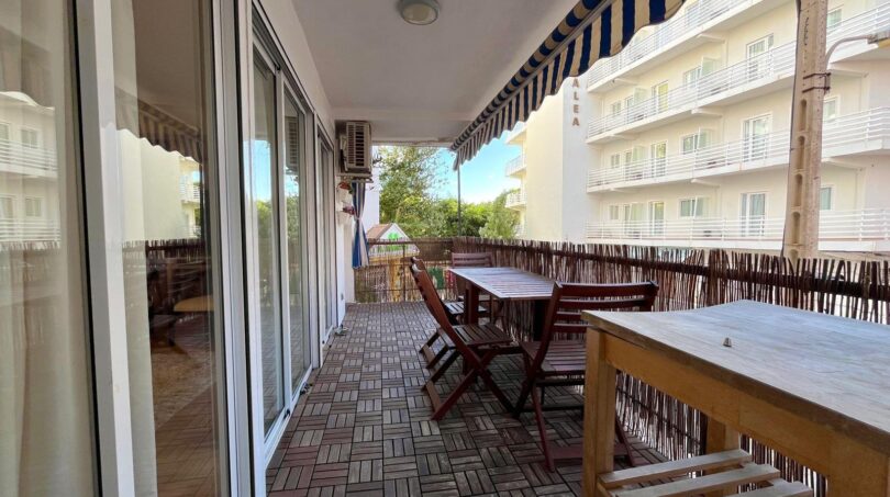 Geräumige Terrasse mit Holzboden, Gartenmöbeln und Markise, Blick auf Nachbargebäude in El Arenal