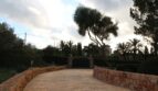 Einfahrt zur Finca in Palma mit Steinmauern, Holztor, Olivenbaum und mediterranem Grün