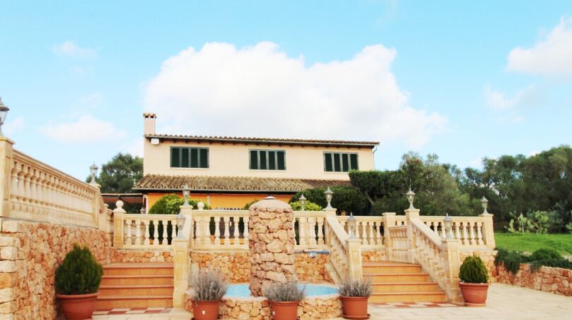 Finca Palma de Mallorca: Außenansicht mit Brunnen, Balustrade, Terrasse und mediterranem Haupthaus mit grünen Fensterläden.