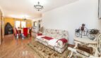 Wohnzimmer der Finca mit Blumensofa, Esstisch, roten Stühlen und Kamin in Palma de Mallorca