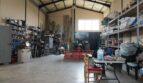 Geräumige Werkstatthalle der Finca mit Traktor, Werkzeugregalen und Garagentor in Son Liebre
