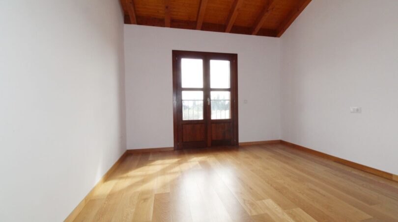 Helles Zimmer mit Holzdielen, Holzbalkendecke und Balkontür in Neubau-Finca, Palma - Son Liebre