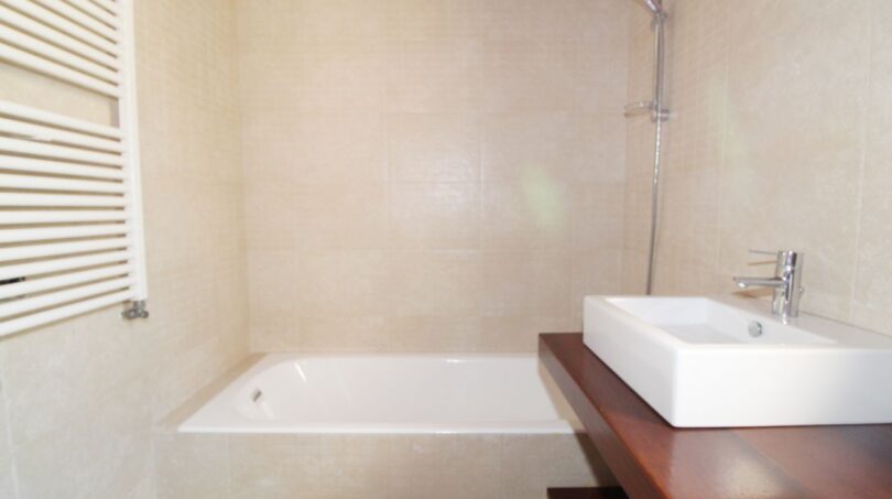 Modernes Badezimmer der Neubau-Finca in Son Liebre mit Einbaubadewanne, Dusche und Holzwaschtisch.