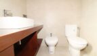 Modernes Badezimmer der Neubau-Finca mit Aufsatzwaschbecken, Bidet und WC auf hellem Fliesenboden.