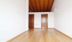 Helles leeres Zimmer mit Holzbalkendecke, Parkettboden und zwei Holztüren in Neubau-Finca Palma
