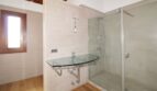 Modernes Badezimmer der Neubau-Finca mit Glaswaschbecken und ebenerdiger Dusche mit Glasabtrennung.
