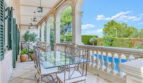 Elegante Säulenterrasse mit Schmiedeeisenmöbeln und Poolblick der Luxusvilla in Llucmajor