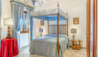 Elegantes Schlafzimmer mit Himmelbett, blauem Baldachin und Muranoglas-Kronleuchter in Luxusvilla Llucmajor