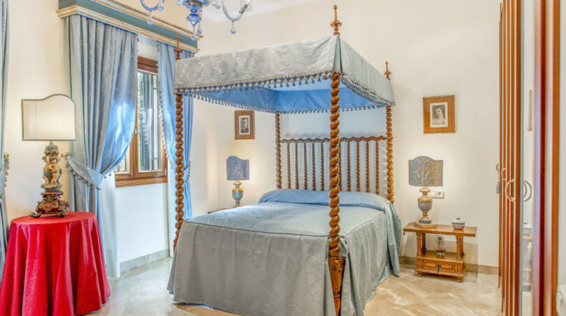 Elegantes Schlafzimmer mit Himmelbett, blauem Baldachin und Muranoglas-Kronleuchter in Luxusvilla Llucmajor