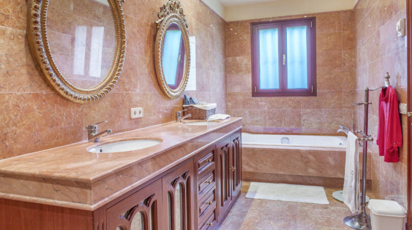 Luxuriöses Marmorbad der Meereslinie-Villa in Llucmajor mit vergoldeten Spiegeln und elegantem Holzwaschtisch