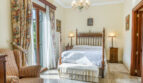 Elegantes Schlafzimmer der Luxusvilla in Llucmajor mit Himmelbett, Kronleuchter und Marmorboden.