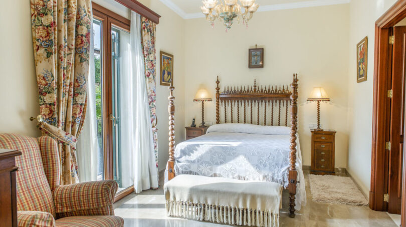 Elegantes Schlafzimmer der Luxusvilla in Llucmajor mit Himmelbett, Kronleuchter und Marmorboden.