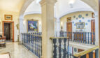 Eleganter Galerieflur mit Bogenkonstruktion, blau-weißem Geländer und Gemälden in Luxusvilla Llucmajor