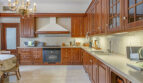 Luxusvilla Llucmajor: Elegante Küche mit Holzschränken, Marmorboden und Kronleuchter