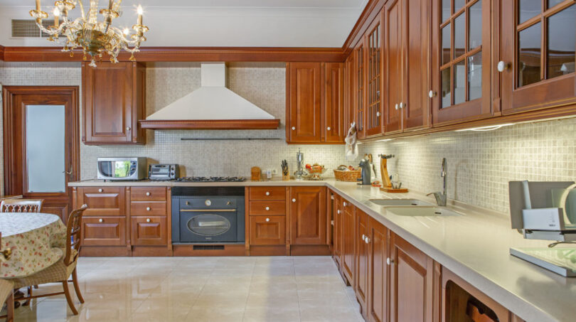 Luxusvilla Llucmajor: Elegante Küche mit Holzschränken, Marmorboden und Kronleuchter