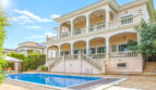 Luxusvilla in Llucmajor: Elegante Außenansicht mit Pool, Doppeltreppe und umlaufenden Balkonen.