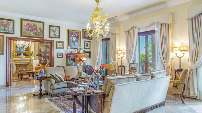 Elegantes Wohnzimmer der Luxusvilla in Llucmajor mit Kronleuchter, Marmorboden und klassischer Einrichtung.