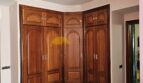 Schlafzimmer mit großem Eckeinbauschrank aus Holz, Marmorböden und Stuckdecke im Stadthaus Inca