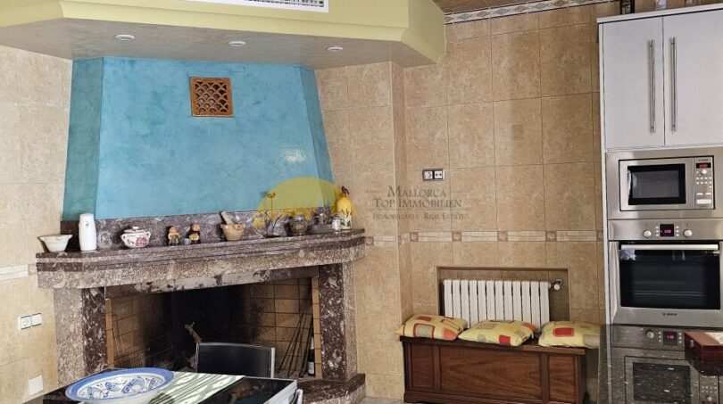 Küche mit offenem Kamin, Einbaugeräten und Essbereich im Stadthaus Inca