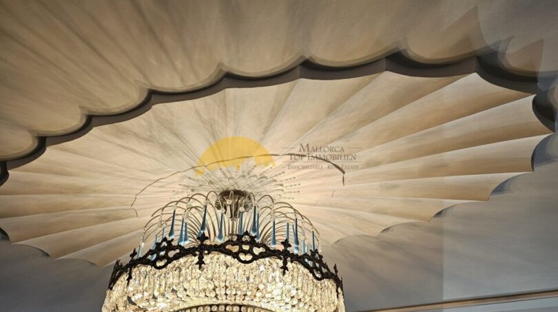 Eleganter Kristalllüster unter dekorativ gefältelter Decke im Stadthaus Inca