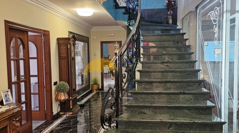 Elegantes Eingangsfoyer mit grüner Marmortreppe, schmiedeeisernem Geländer und schwarzem Marmorboden im Stadthaus Inca