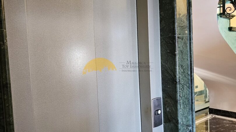 Eleganter Aufzug mit Edelstahltüren und grünem Marmorrahmen im Stadthaus Inca