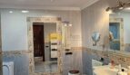 Elegantes Badezimmer im Stadthaus Inca mit Marmorfliesen, Doppelwaschbecken und dekorativem Wandspiegel.