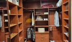 Geräumiges Ankleidezimmer mit Holzeinbauten, Schubladen und Hängestangen im Stadthaus Inca