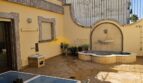 Sonnige Dachterrasse mit Springbrunnen, Sitzbereich und Steindekor des Stadthauses in Inca