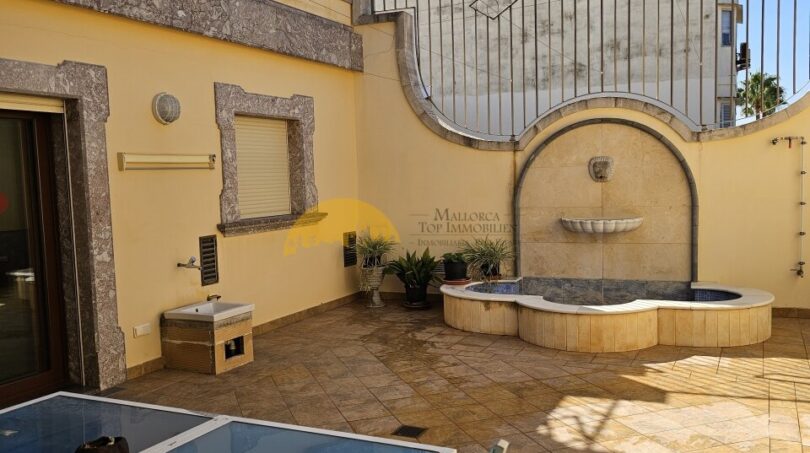 Sonnige Dachterrasse mit Springbrunnen, Sitzbereich und Steindekor des Stadthauses in Inca