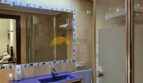 Modernes Bad im Stadthaus Inca mit blauem Waschtisch, Glasdusche und Marmorfliesen