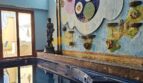 Innenpool mit Kunstwand, klassischer Statue und Mosaikelementen im Stadthaus Inca