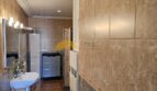 Geräumiges Badezimmer mit Marmoroptik-Fliesen, Waschtisch und Heizkörper im Stadthaus Inca
