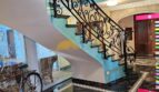 Elegante Wendeltreppe mit Schmiedeeisen-Geländer und schwarzem Marmorboden im Stadthaus Inca