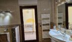 Elegantes Badezimmer mit Marmorfliesen, Doppelwaschbecken und Handtuchheizkörper im Stadthaus Inca