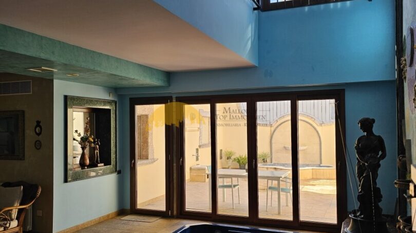 Stadthaus Inca: Innenpool mit blauer Kacheln, Glasfront zum Patio, Galerie und klassischer Skulptur