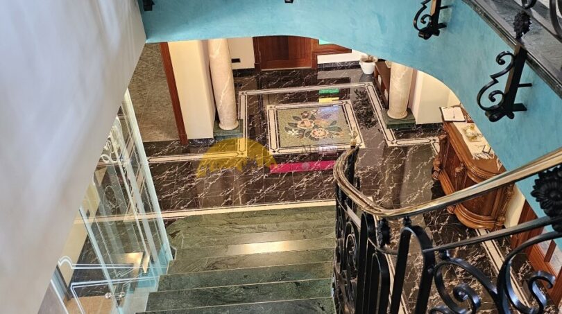 Geschwungene Marmortreppe mit schmiedeeisernem Geländer im eleganten Stadthaus in Inca