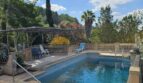 Außenpool der Finca bei Inca mit Pergola, Liegestühlen und üppigem mediterranem Garten mit Palmen.