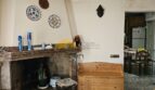 Wohnzimmer der Finca bei Inca mit Marmorkamin, Holzbank und dekorativen Keramiktellern an der Wand.