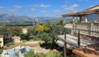 Finca-Anwesen bei Inca: Terrasse mit Balustrade, Pool, Garten und Bergpanorama unter blauem Himmel.