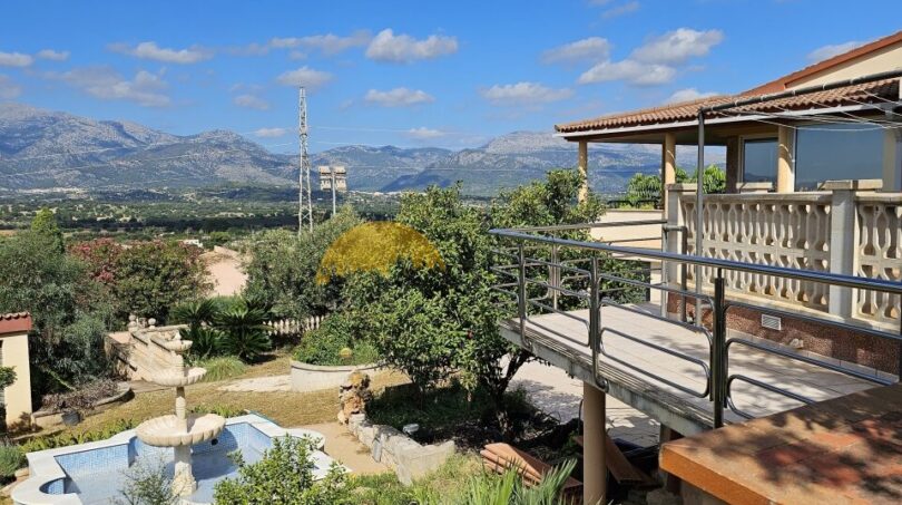 Finca-Anwesen bei Inca: Terrasse mit Balustrade, Pool, Garten und Bergpanorama unter blauem Himmel.
