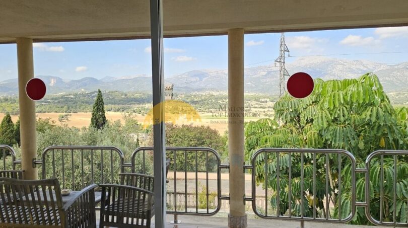 Verglaste Terrasse mit Panoramablick auf Berglandschaft und Felder, Finca-Anwesen bei Inca, Mallorca.
